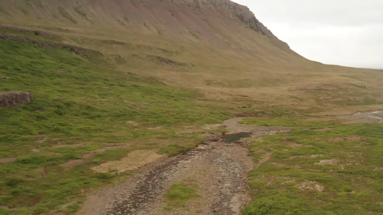 Steep hills of Iceland's westfjords on cloudy day drone shot