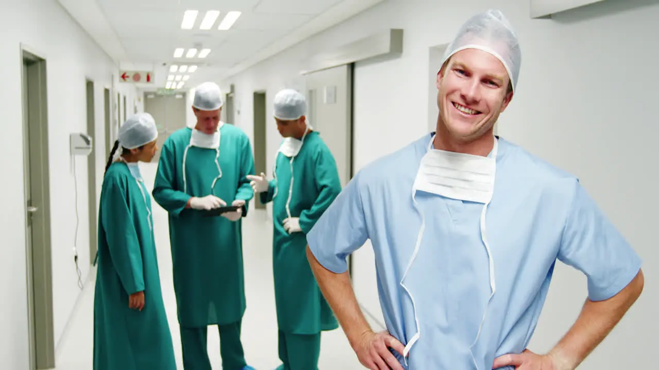 Portrait of male surgeon standing with hands on hips