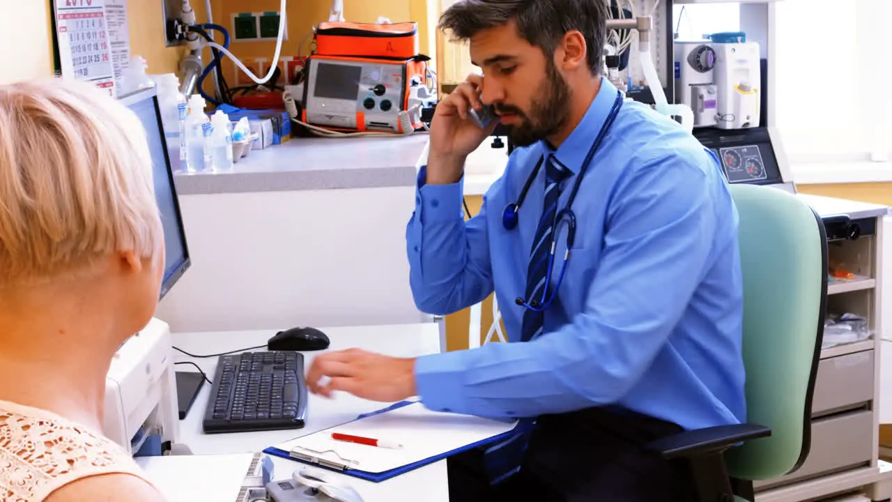 Doctor sitting at his desk and talking on phone