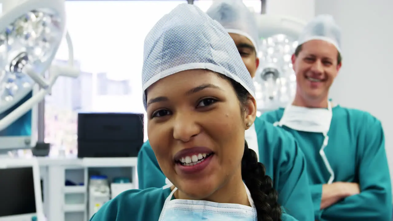 Portrait of surgeons and nurse standing with arms crossed in operation room