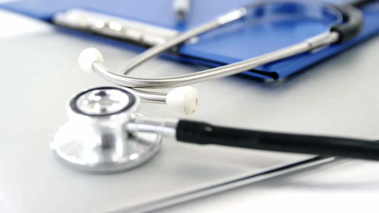 Close-up of folder file and pen with stethoscope