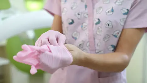 Close up doctor hands putting on surgical gloves Woman dentist hands