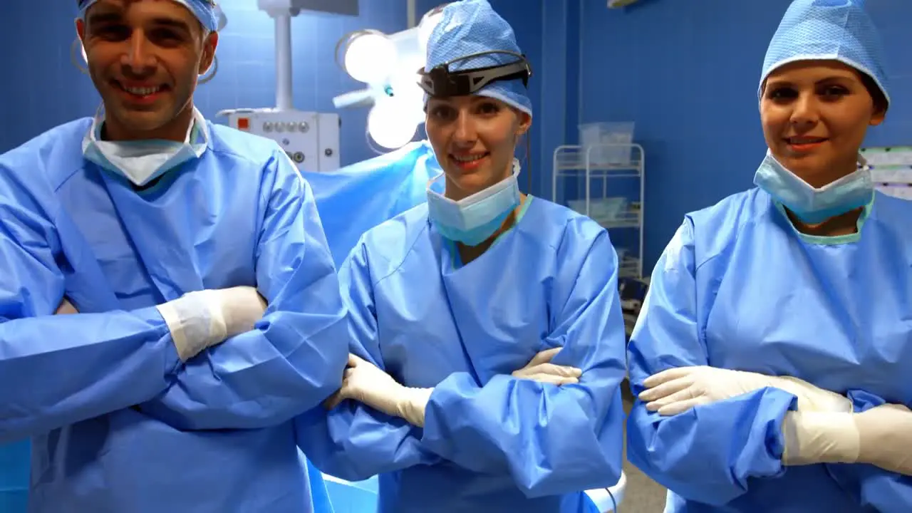 Portrait of surgeon and nurses standing with arms crossed in operation room