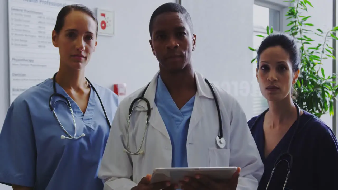 Front view of multi-ethnic doctors standing in the corridor at hospital 4k