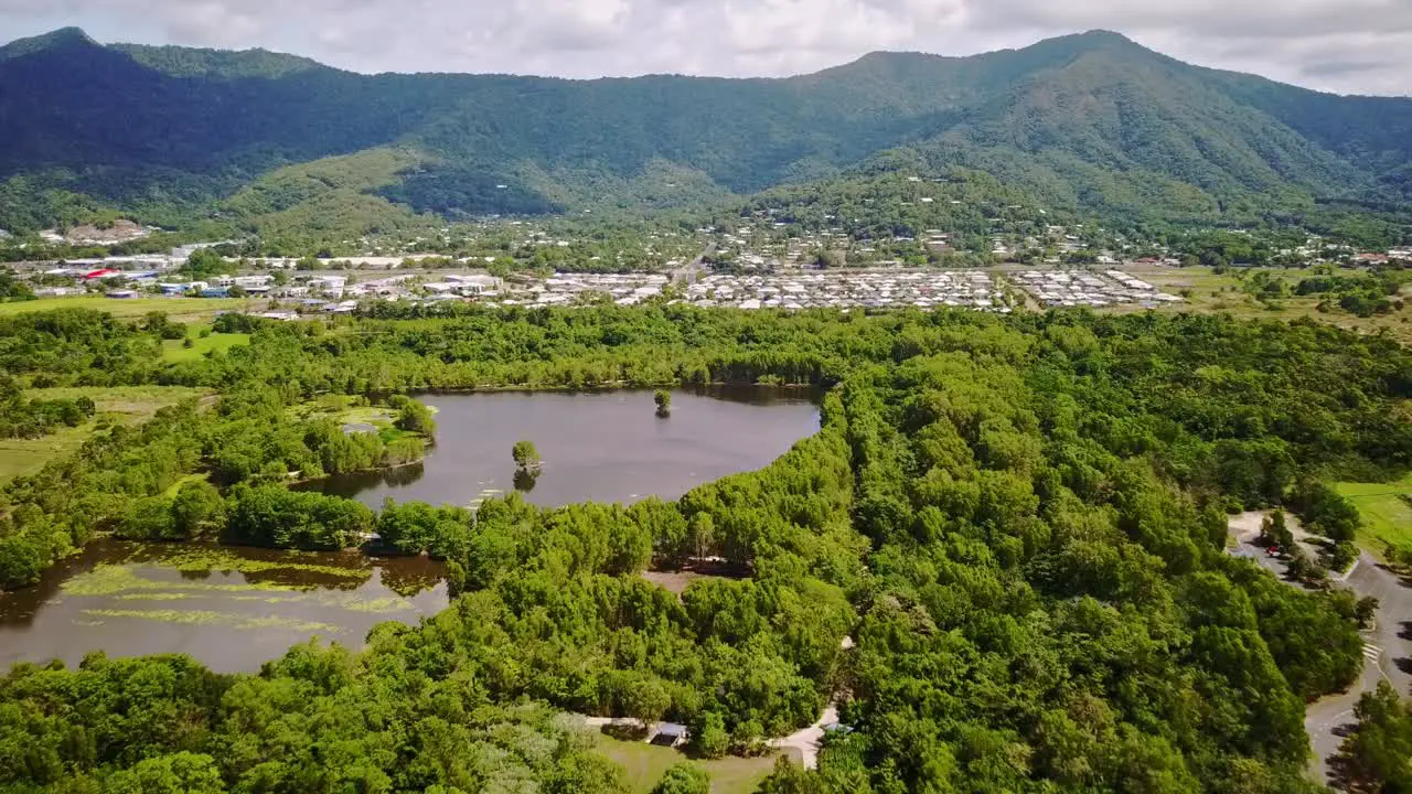 Aerial footage of Cattana Wetlands urban area of Smithfield and forested mountains near Cairns Queensland Australia