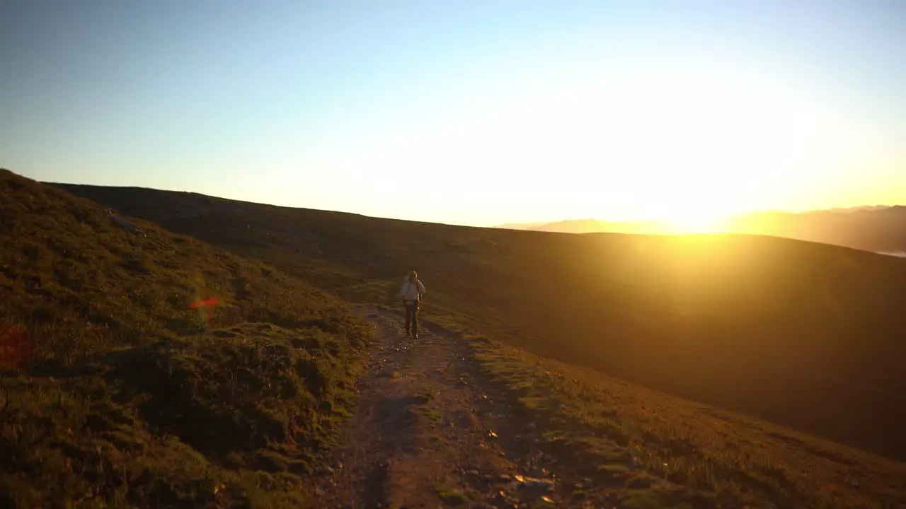 Backpacking man sunrise sunshine hiking in nature treeless wilderness