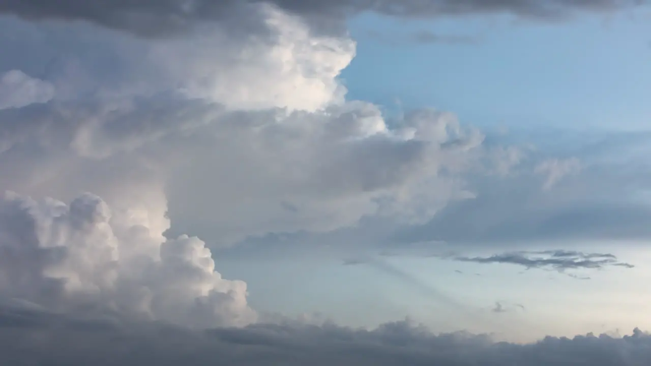 Time Lapse of large tropical storm cloud morphing into different shapes as night falls