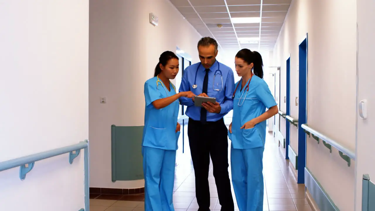 Doctor and nurses discussing over digital tablet