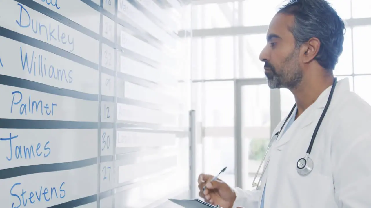 Male doctor checking information board 4k