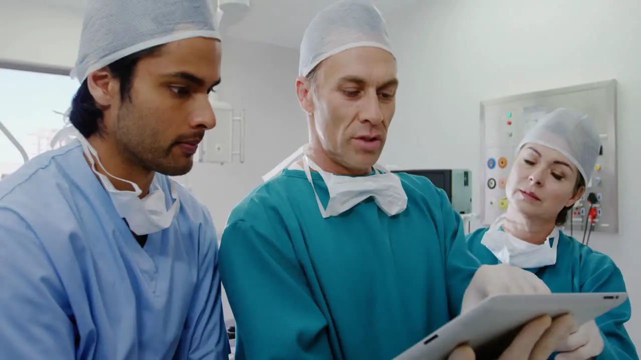 Surgeons discussing over digital tablet in operation room