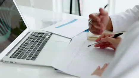 Hands documents and writing with a medical team