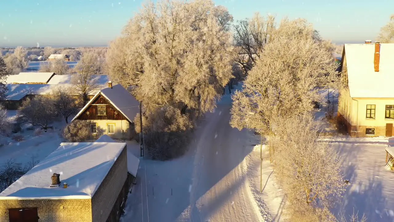 Small street and rural residential buildings in winter season aerial descend view