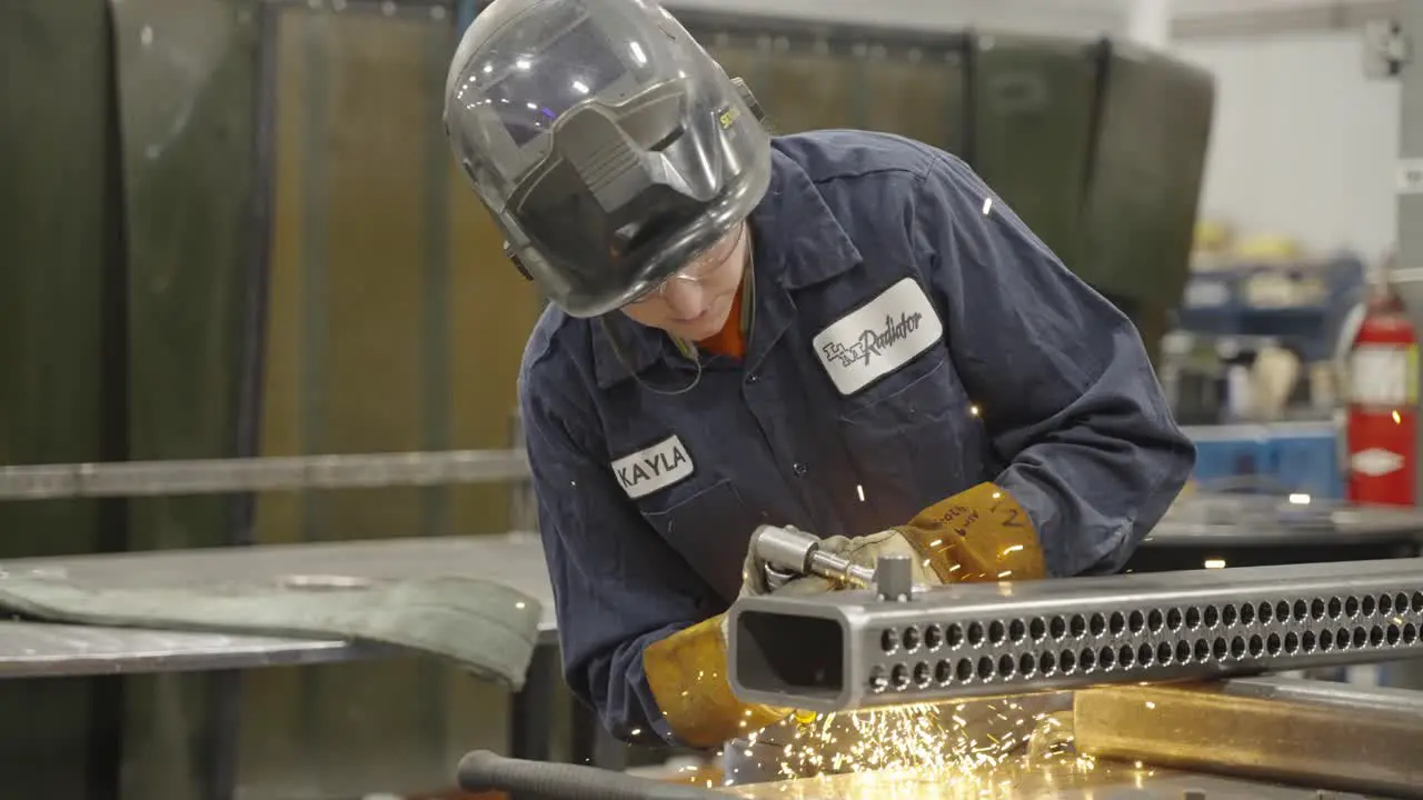 Slow mo blue collar worker welding piece of metal in workshop