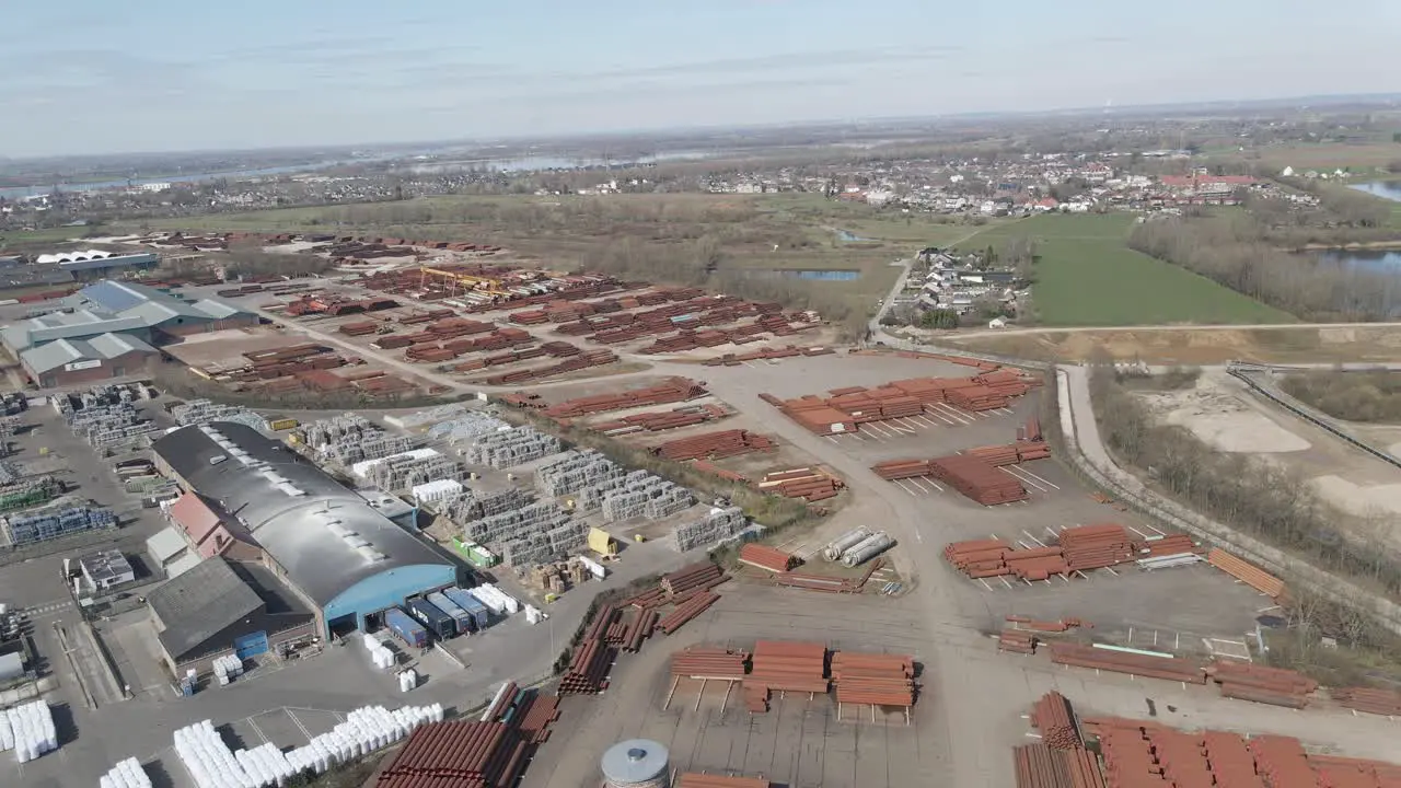 Flying over old smoke stack overlooking large industrial junk yard