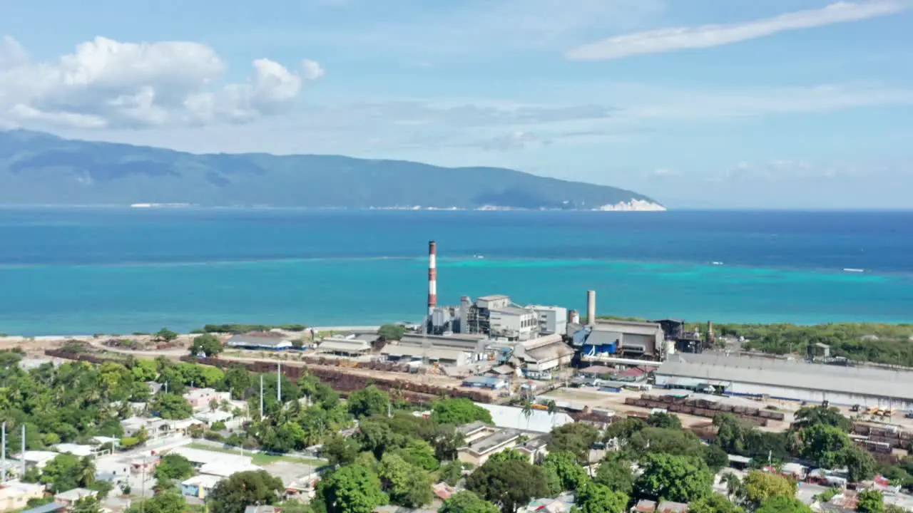 Aerial view of sugar mill factory in front of tropical Caribbean Sea in background during sunny day Barahona Dominican Republic