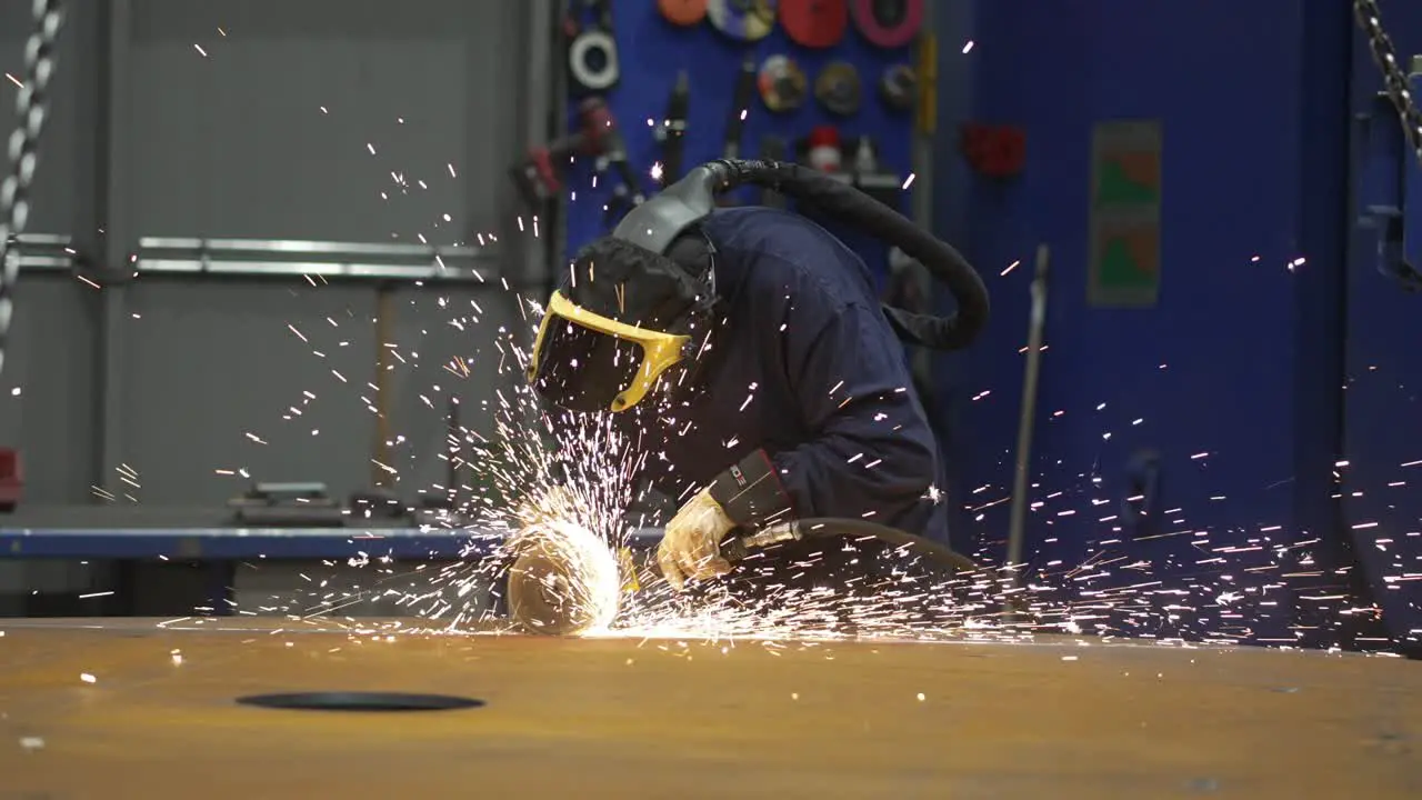 worker using an angle grinder on metal