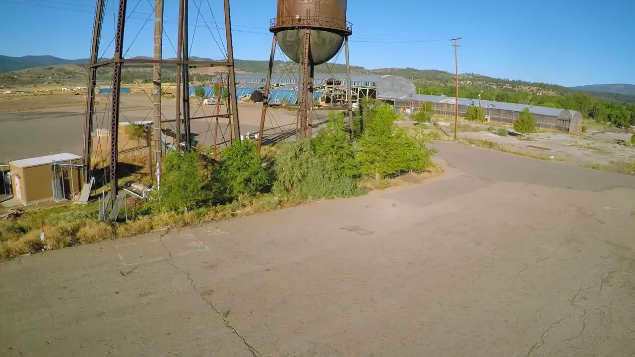 An aerial rising shot over an abandoned factory mill and water towers in Northern California