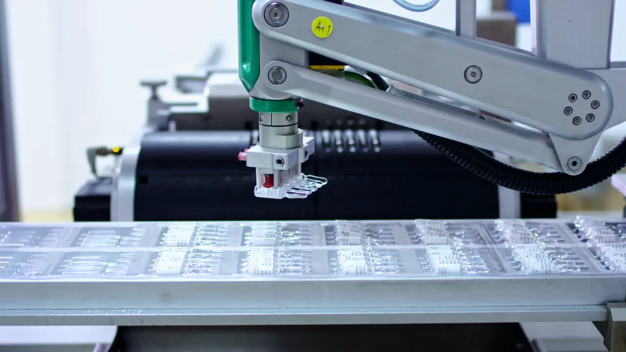 Pharmaceutical industry Robotic arm put ampoules at pharmacy manufacturing line