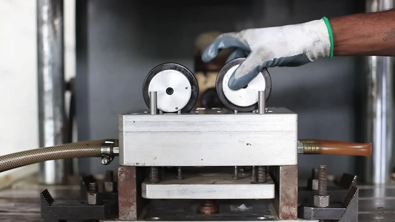 Close-up scene of an operator removing the finished wax mold from the press machine