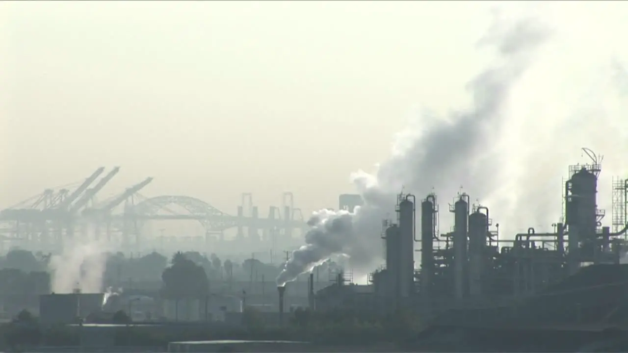 Smoke rises from a petrochemical factory or oil refinery under a cloudy sky 1