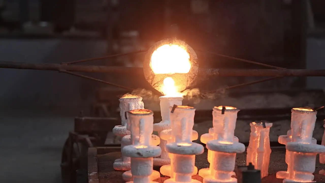 slow motion scene of castings heated at high degrees Celsius being carefully filled into moulds