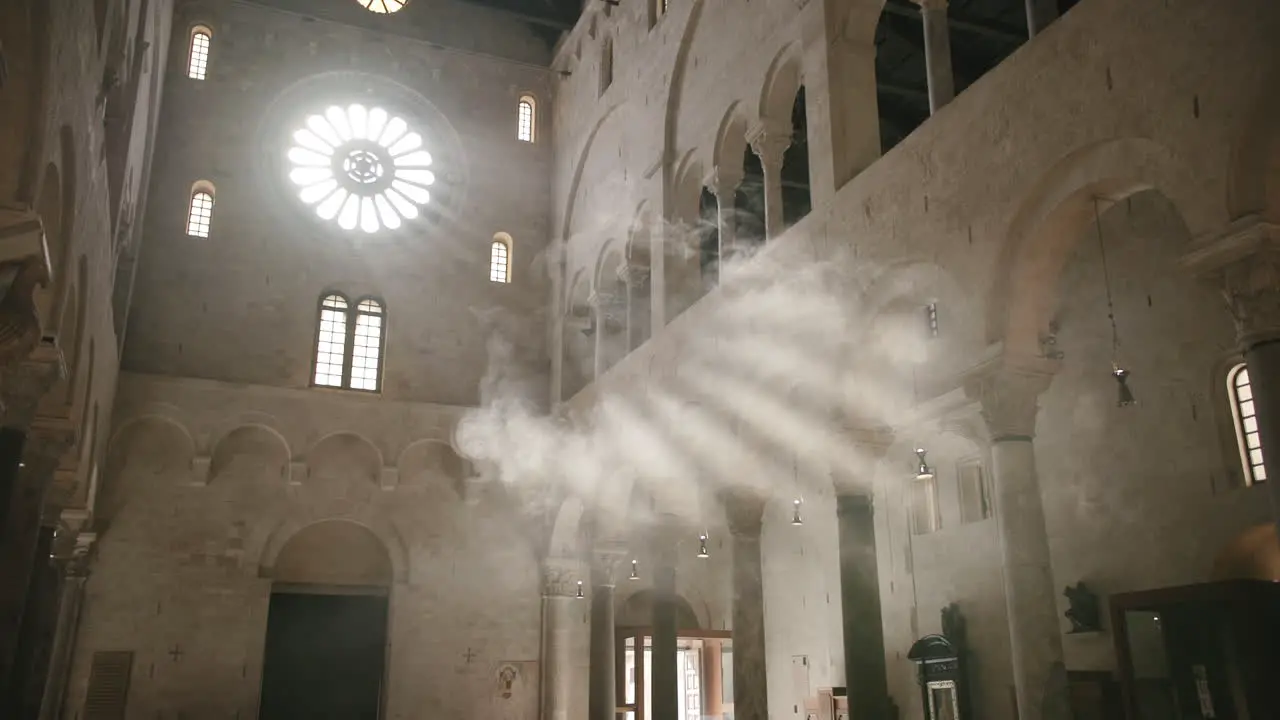 Slow motion footage of rays of the sun shining through a window of a church illuminated by smoke in Bari Italy