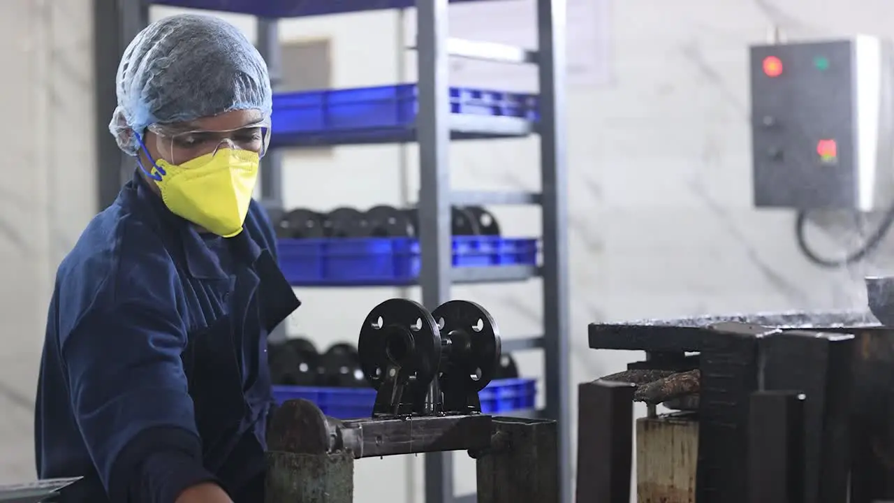 Medium sort employee working on jointing components of wax mold wearing safety bears