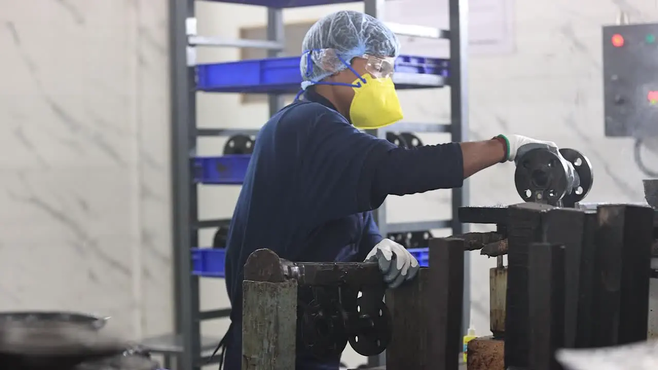 An employee in an investment casting foundry works on gluing a mold made of wax