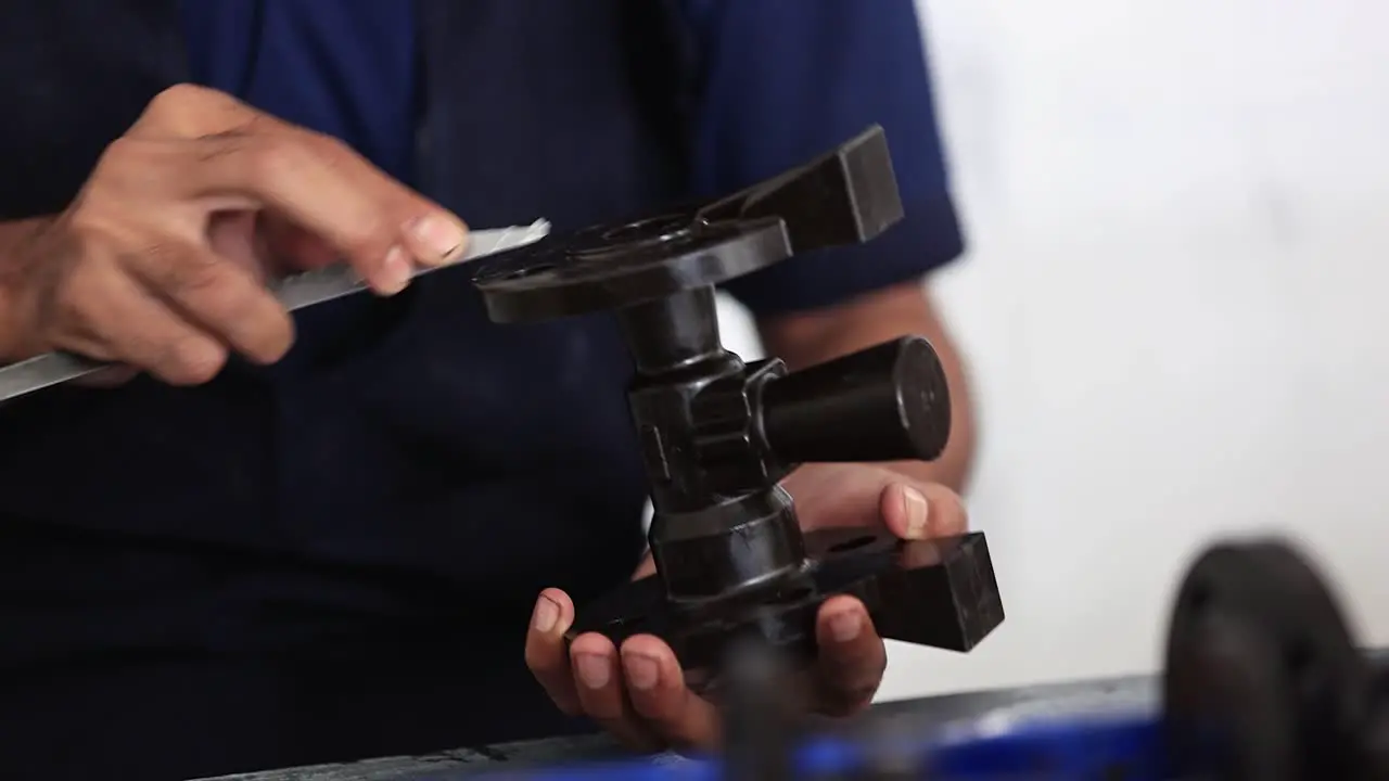 close-up scene in which an employee is checking the quality of a wax mole pattern prepared by an employee