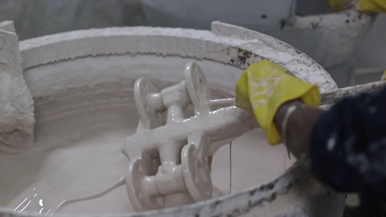 slow motion scene in which the operator is soaking the mold in sand