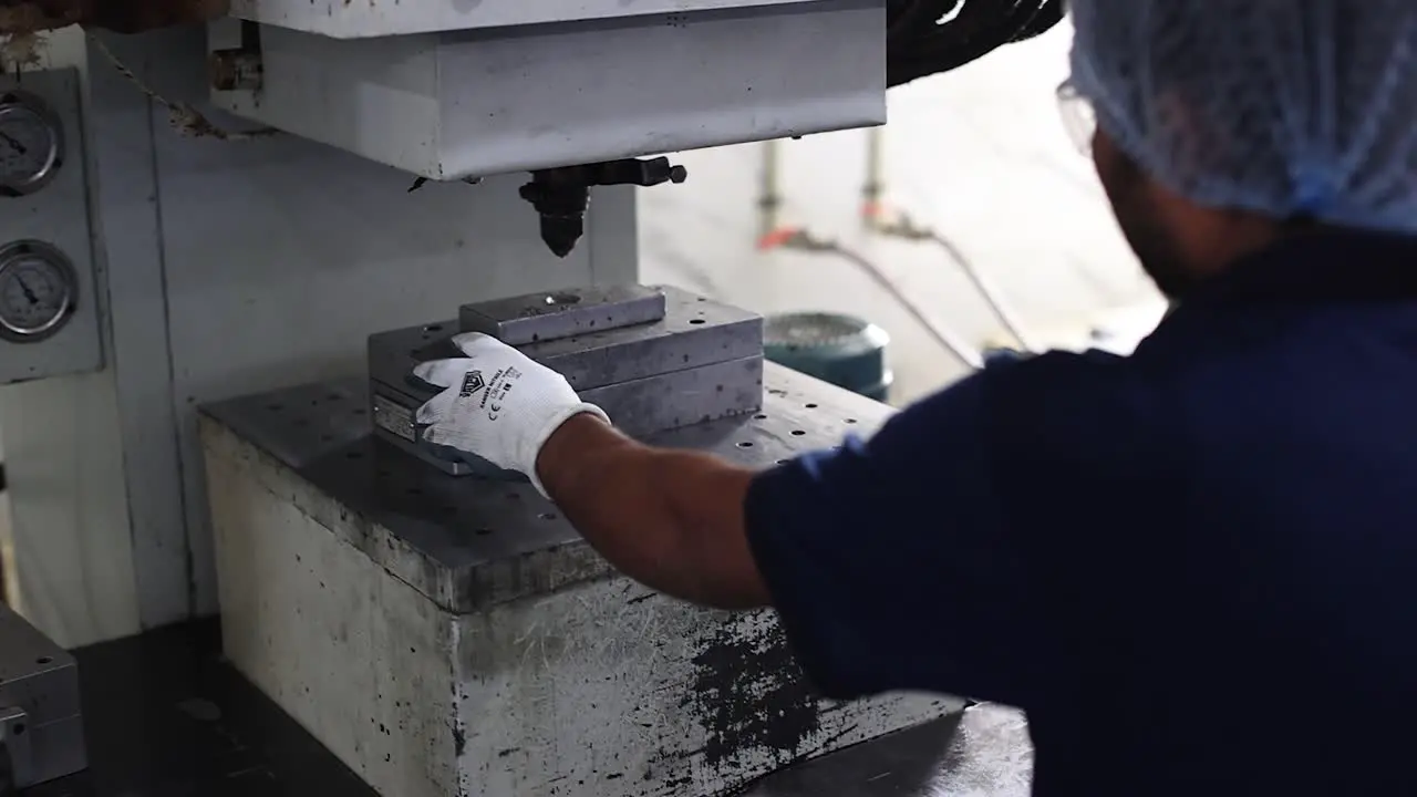 Scene machines operator from front applying spray to die mold to prevent lost wax from sticking