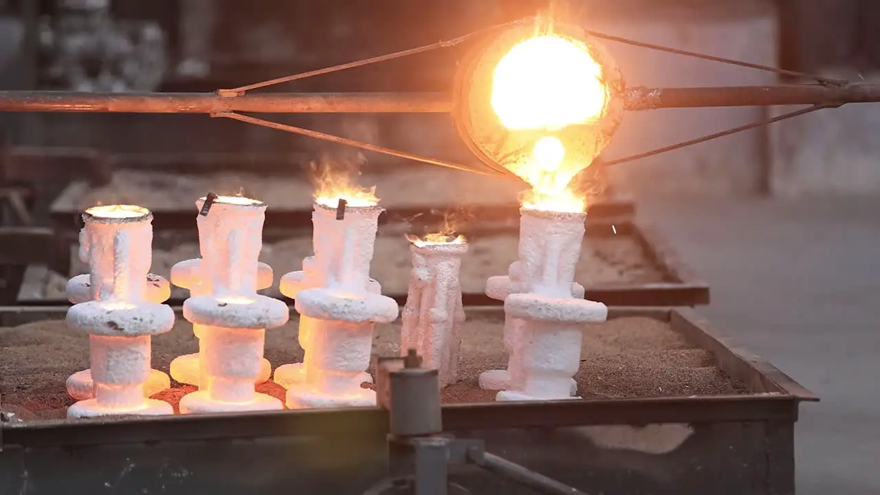 Close up of scene casting finished iron being filled into moulds