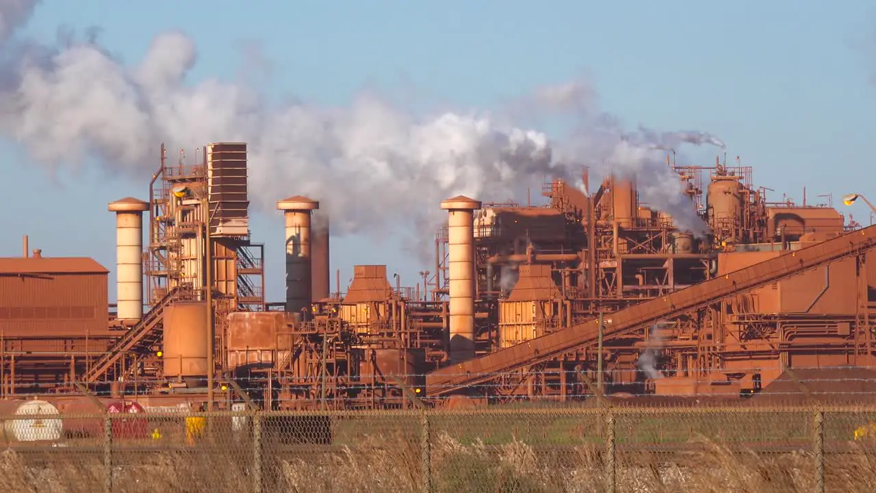 An aluminum refinery emits smoke clouds