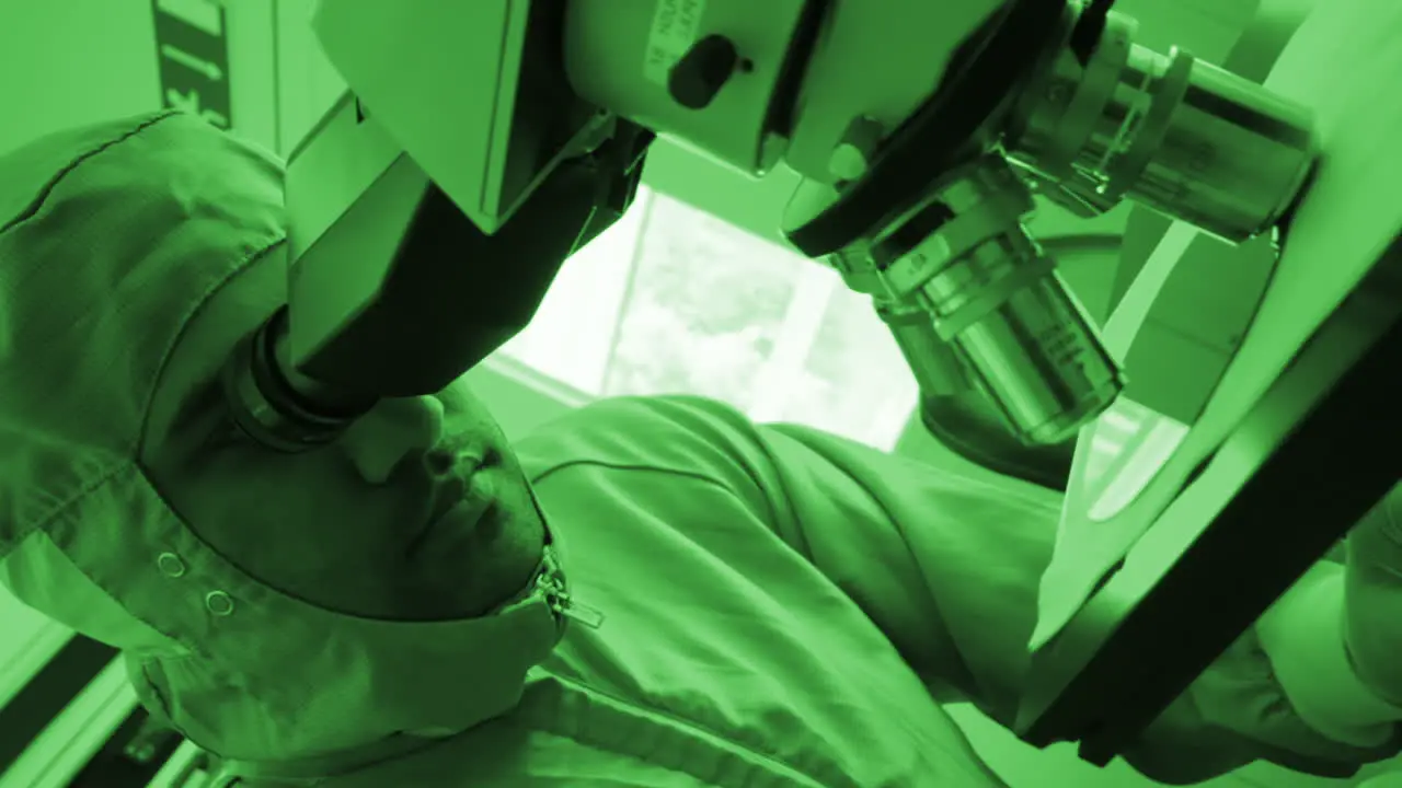 Hospital worker looking in a microscope Laboratory scene Close Up