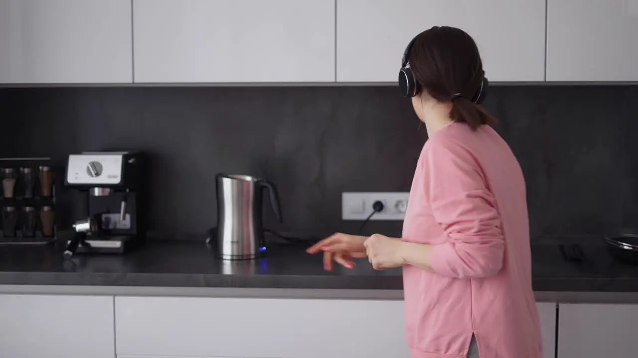 Portrait Of Girl Posing In Kitchen Listening To Songs In Headphones