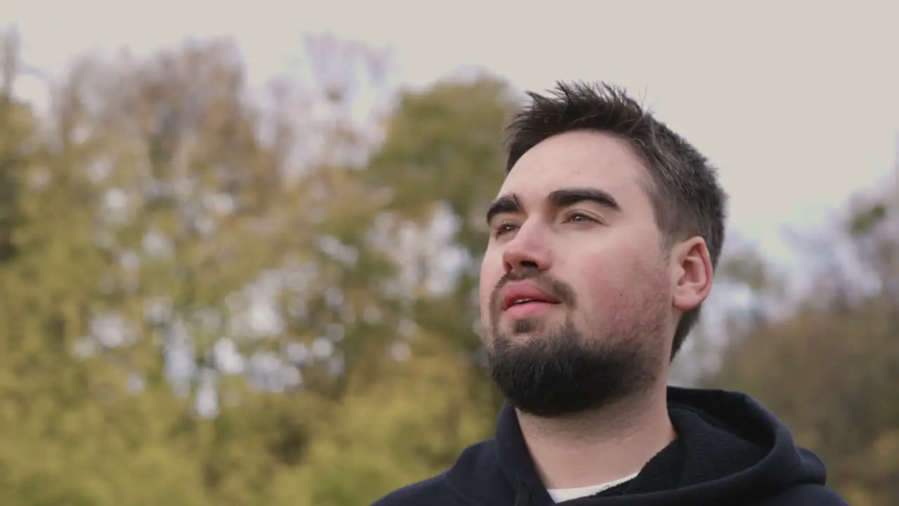 Portrait Of A Bearded Man Relaxing And Looking At Something While Standing At Park In The Morning