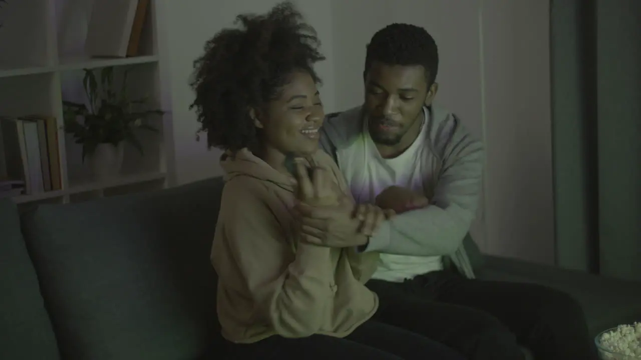 Young Couple Fighting For Remote Control And Having Fun