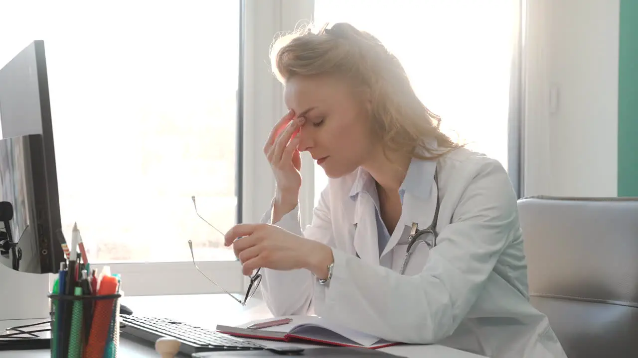 Tired Female Doctor Having Headache At Work