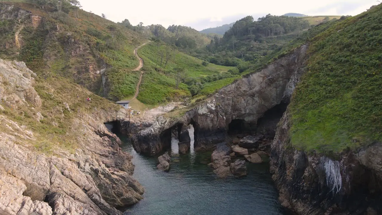 Aerial View Of Beautiful Wild Cliff Coastline While Group Of People Hiking And Enjoying The Views On A Summer Day