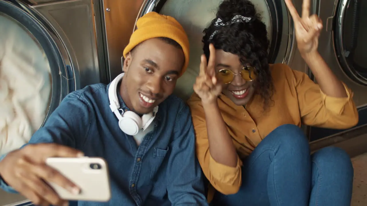 Cheerful Couple Smiling To Smartphone Camera While Taking Selfie Photo In Laundry Service