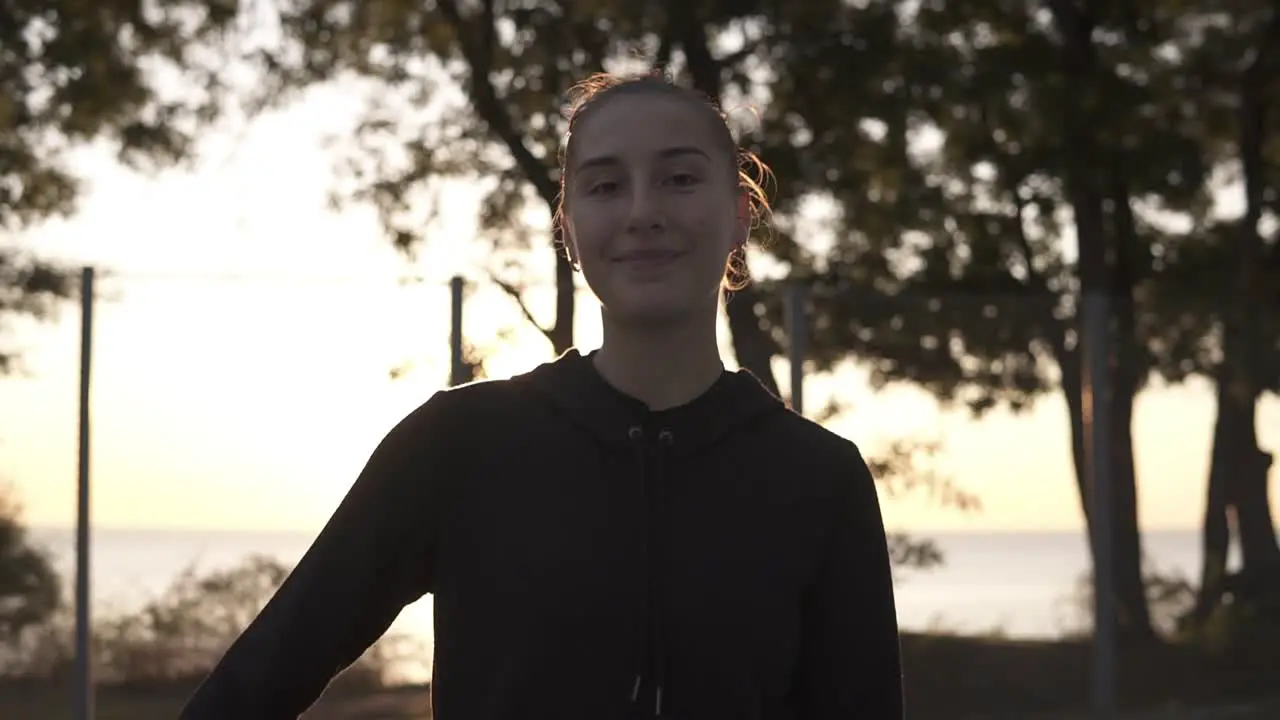 Footage From Down And Up Below A Full Length Of A Young Female Basketball Player In Hoodie And Shorts Standing On A Local Basketball Court With Ball In Her Hand