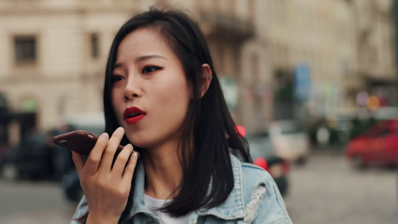 Close Up Of The Young Pretty Girl Talking And Recording A Voice Audio Message On The Smartphone In The City Center