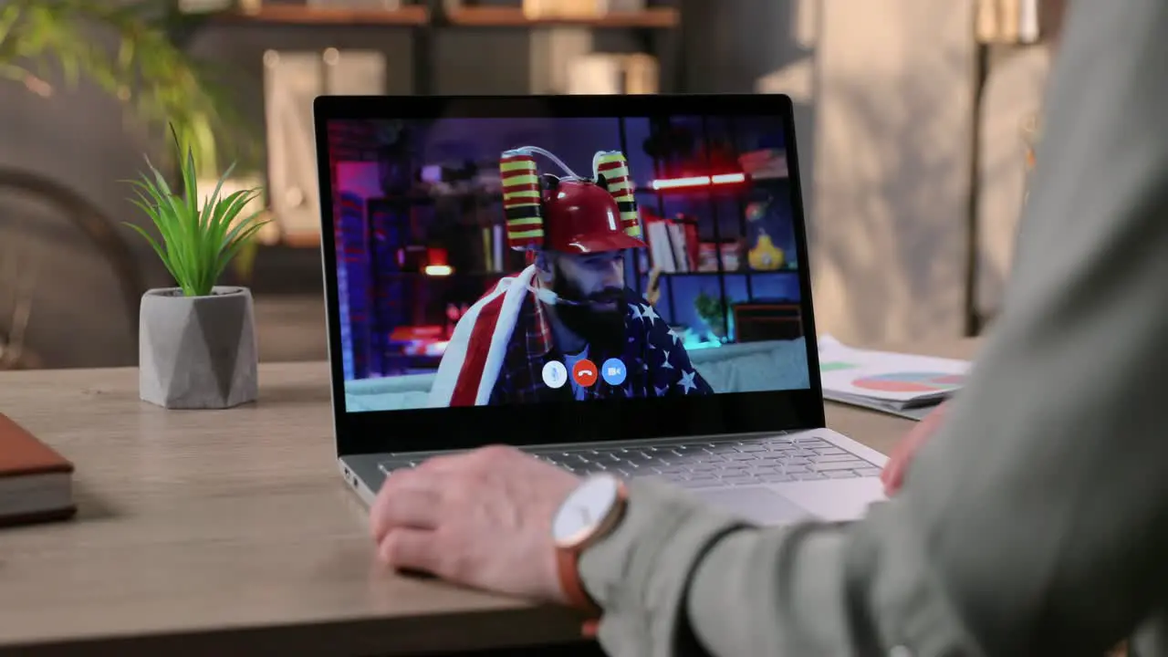 Woman Speaking On Video Conference On Laptop With Cheerful Man With Drinking Hat At Home