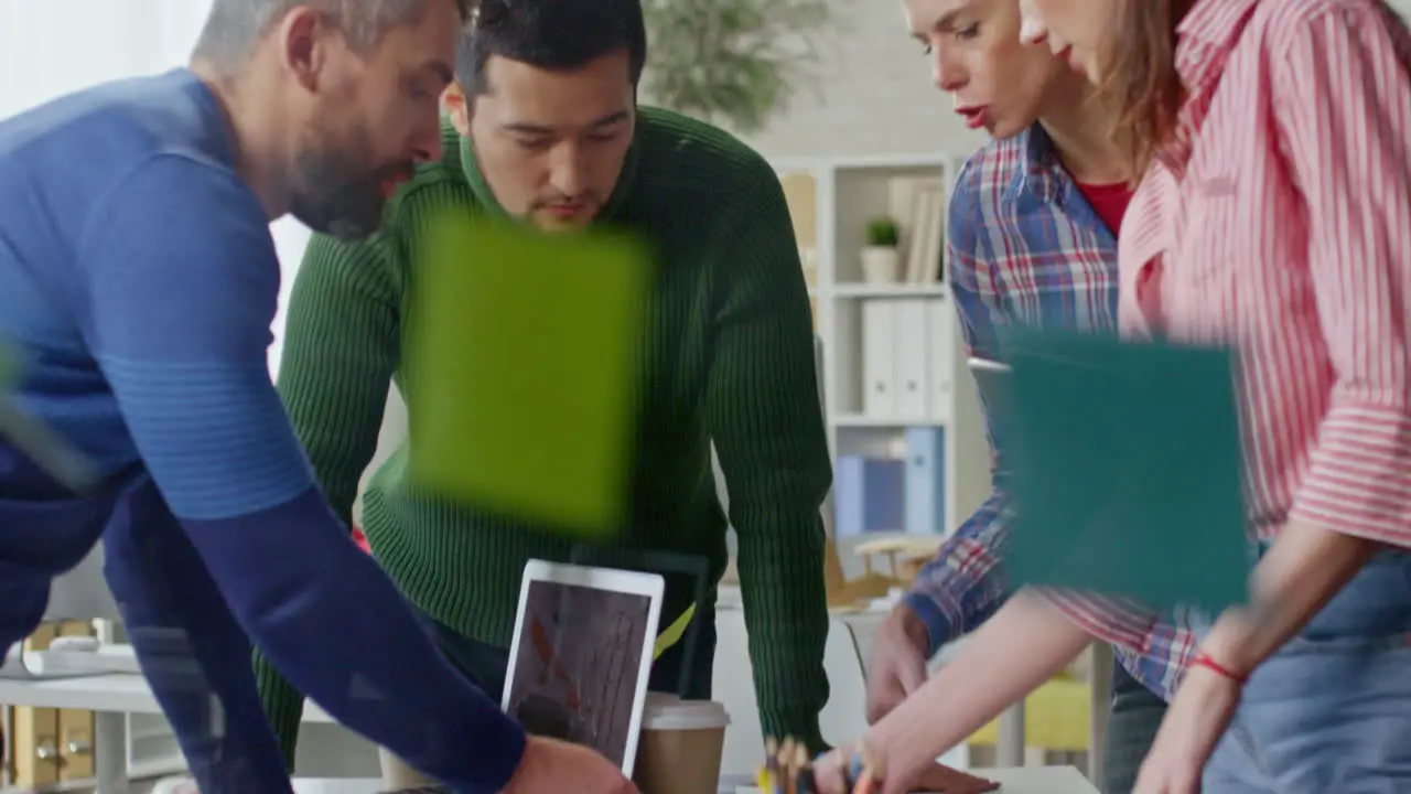 Group Of Coworkers Stand Around The Table