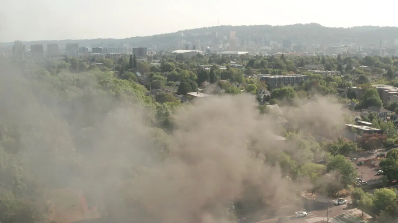 Dolly back aerial shot over a burning building in American city suburbs