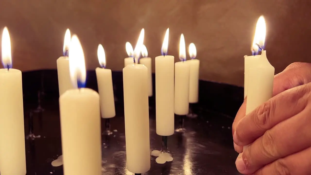 Praying hands with prayer candle