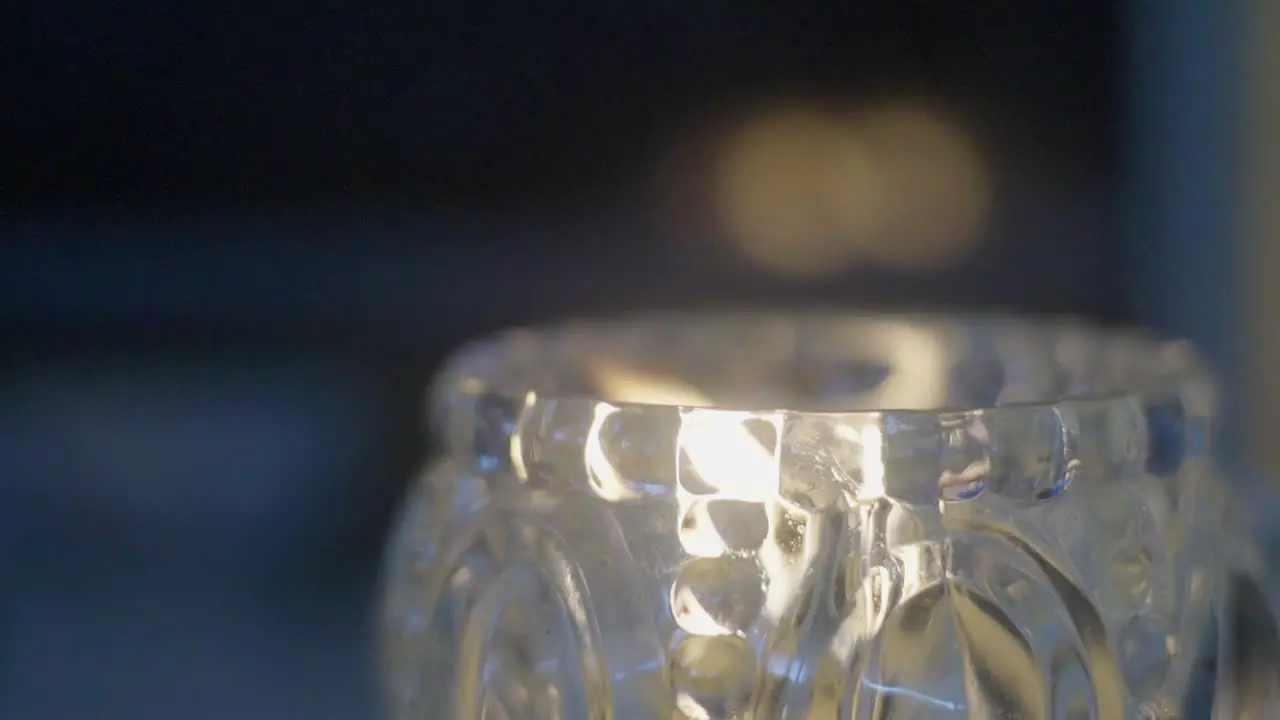 Closeup of a scented candle burning inside a glass flask