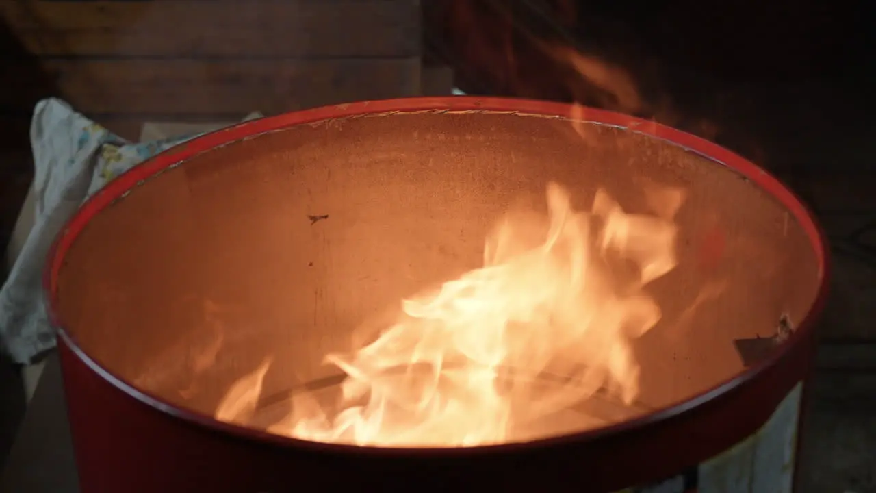 Fire or Flame Inside Metal Barrel At Night in City Street