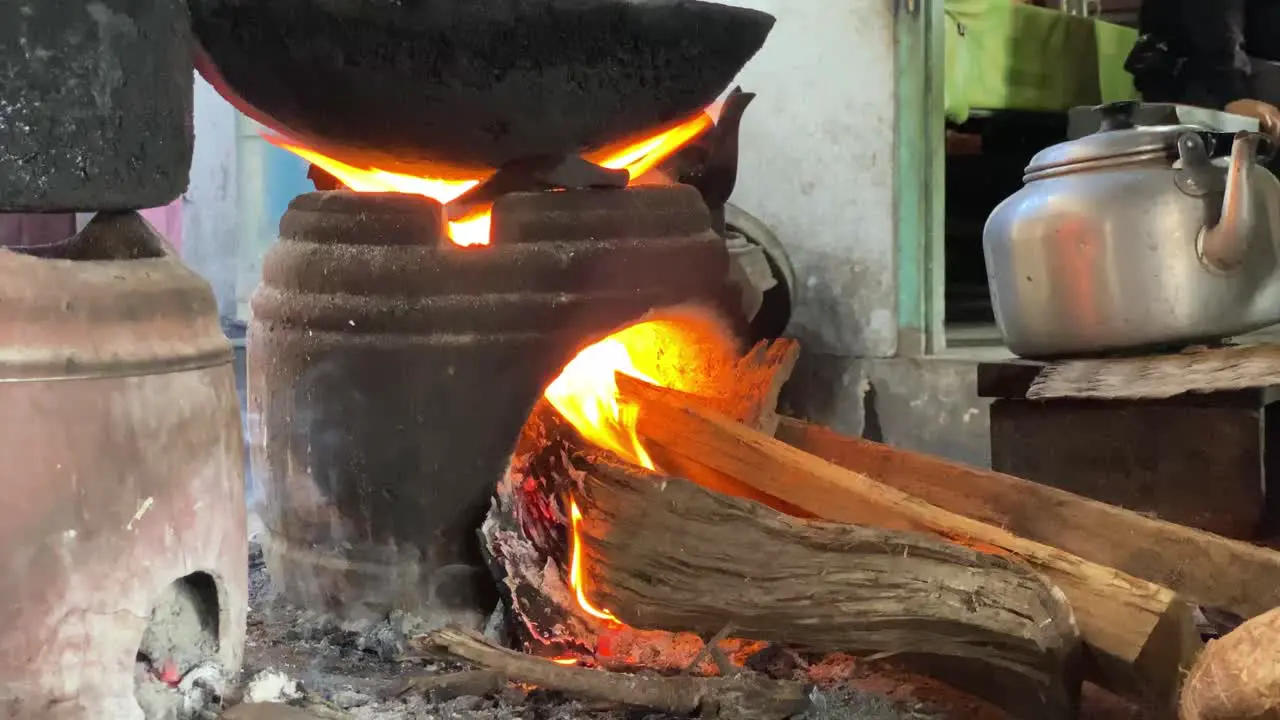 Close-up of a traditional stove and a smoldering fire in the process of cooking fried food