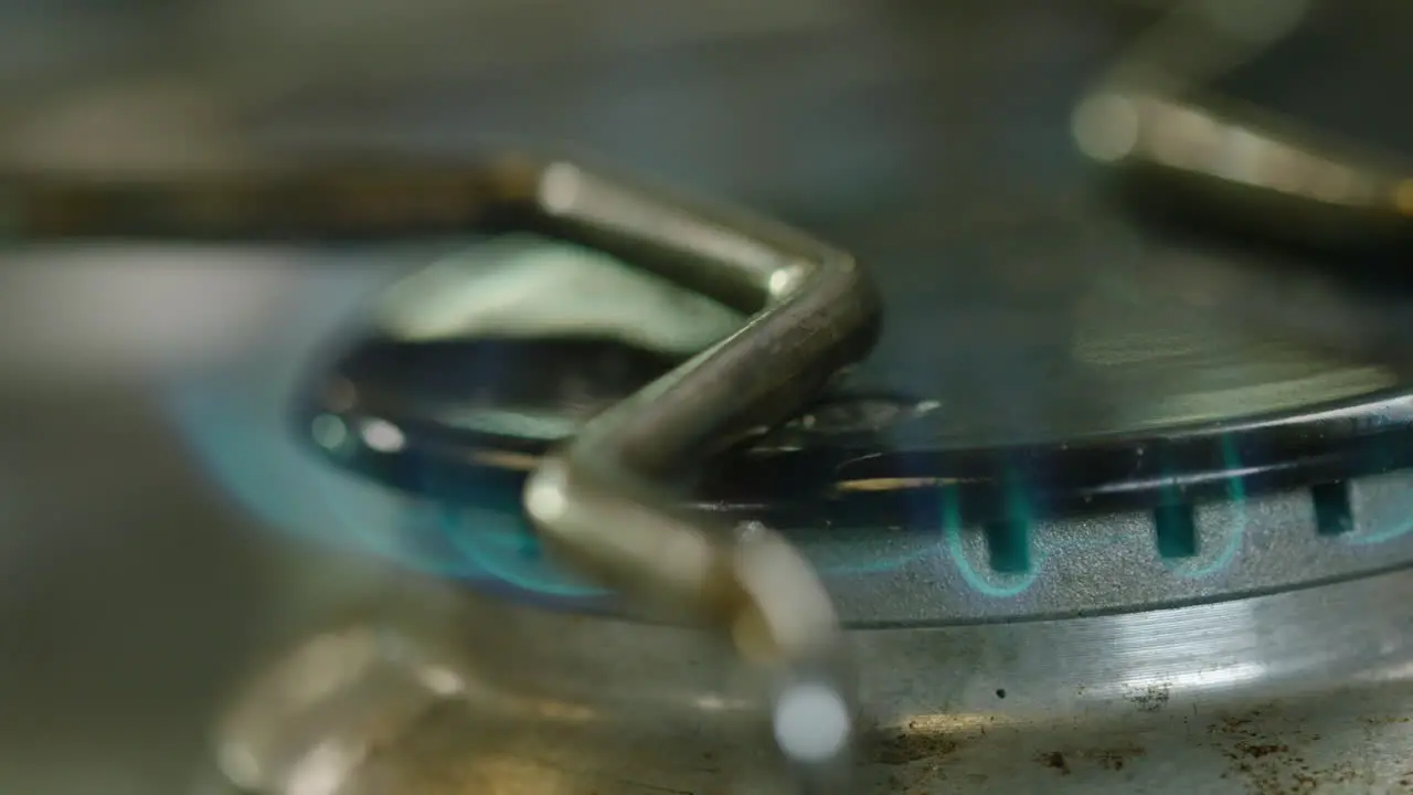 SHALLOW FOCUS MACRO shot of a gas cooker hob burning blue